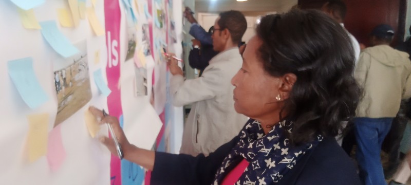 A woman studies images and text about water values in a display, and other people look at other parts of the display behind her